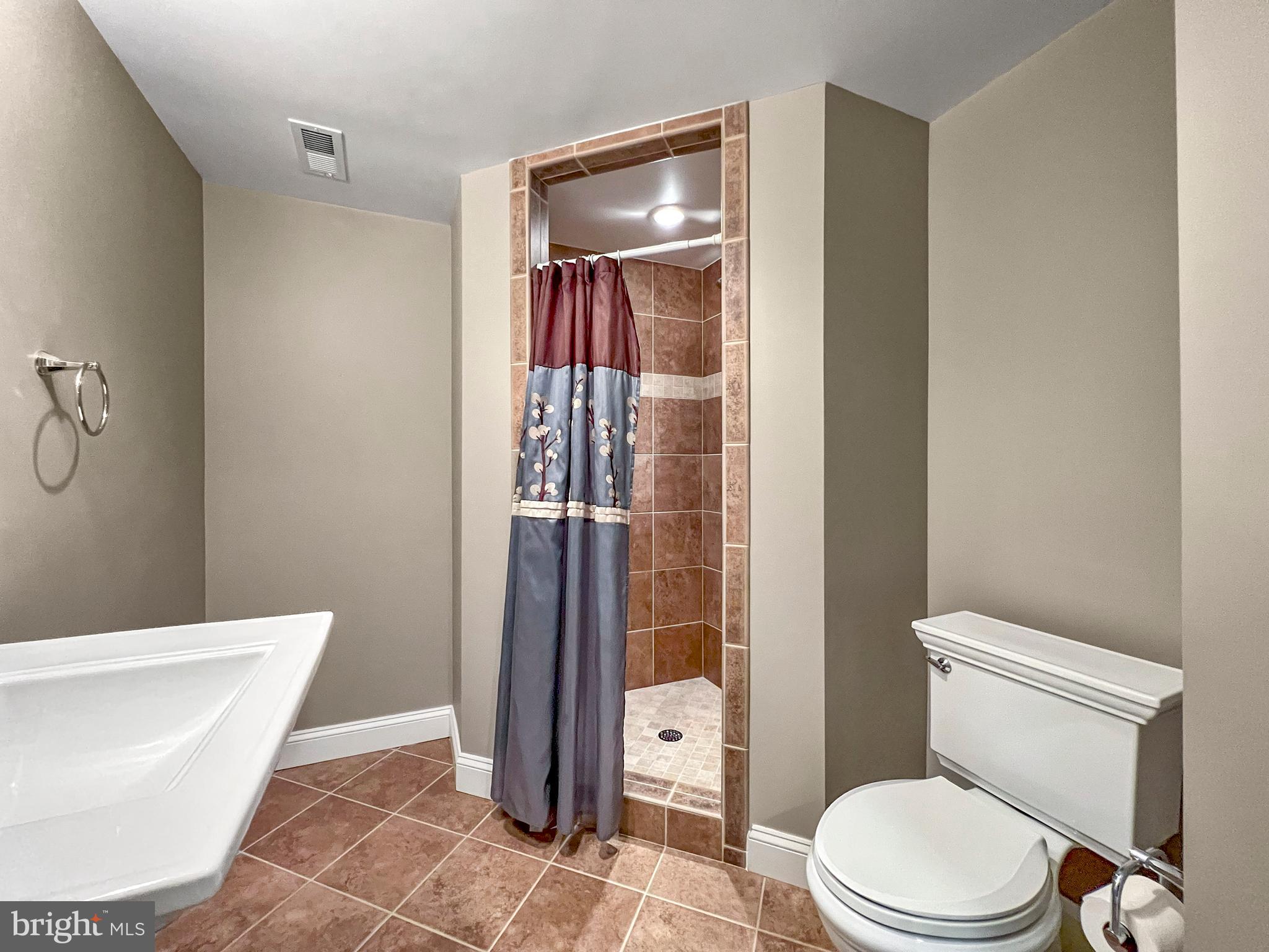 22773 Highcrest Circle Brambleton, VA 20148 - Photo 32 of 40 a white toilet sitting next to a bathroom sink and a shower