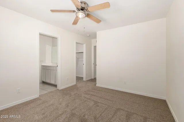 an empty room with closet and a chandelier fan