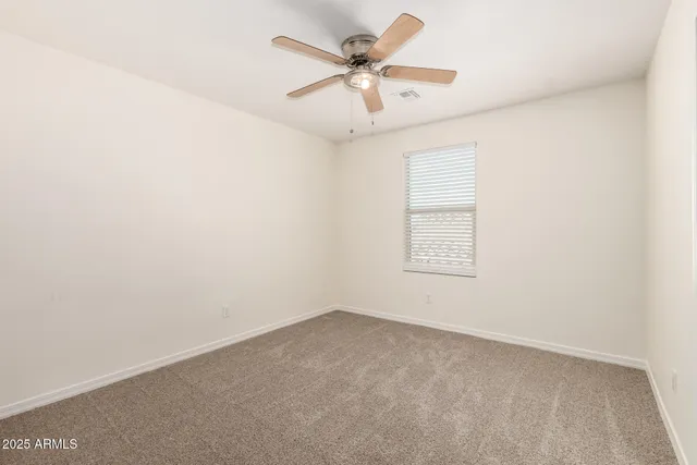 an empty room with a window and a ceiling fan