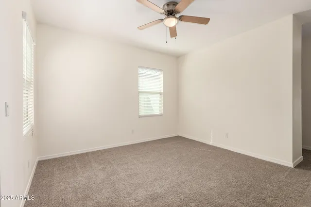 an empty room with a window and a fan