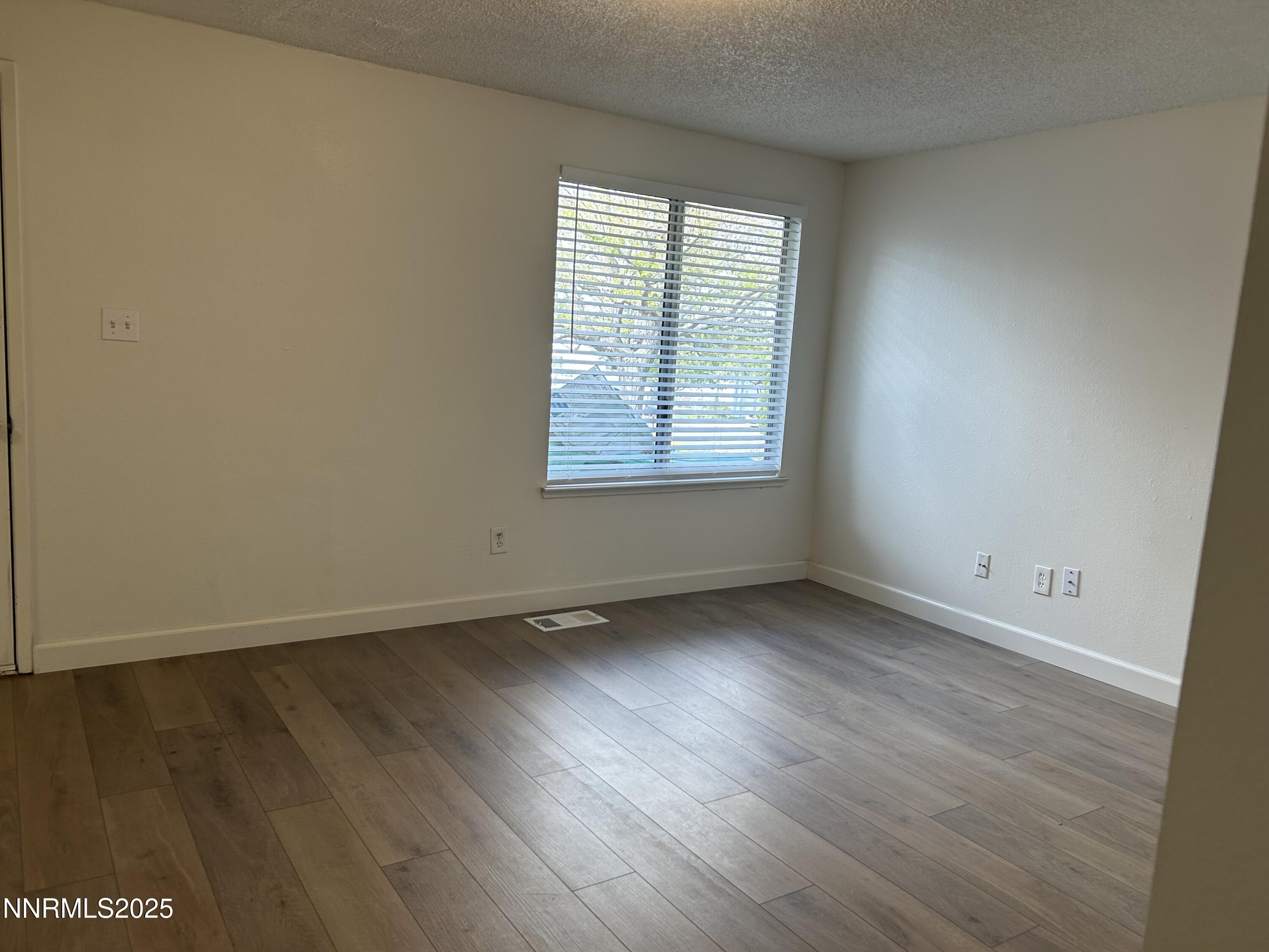 6780 Peppermint Drive Reno, NV 89506 - Photo 11 of 16 an empty room with wooden floor and windows