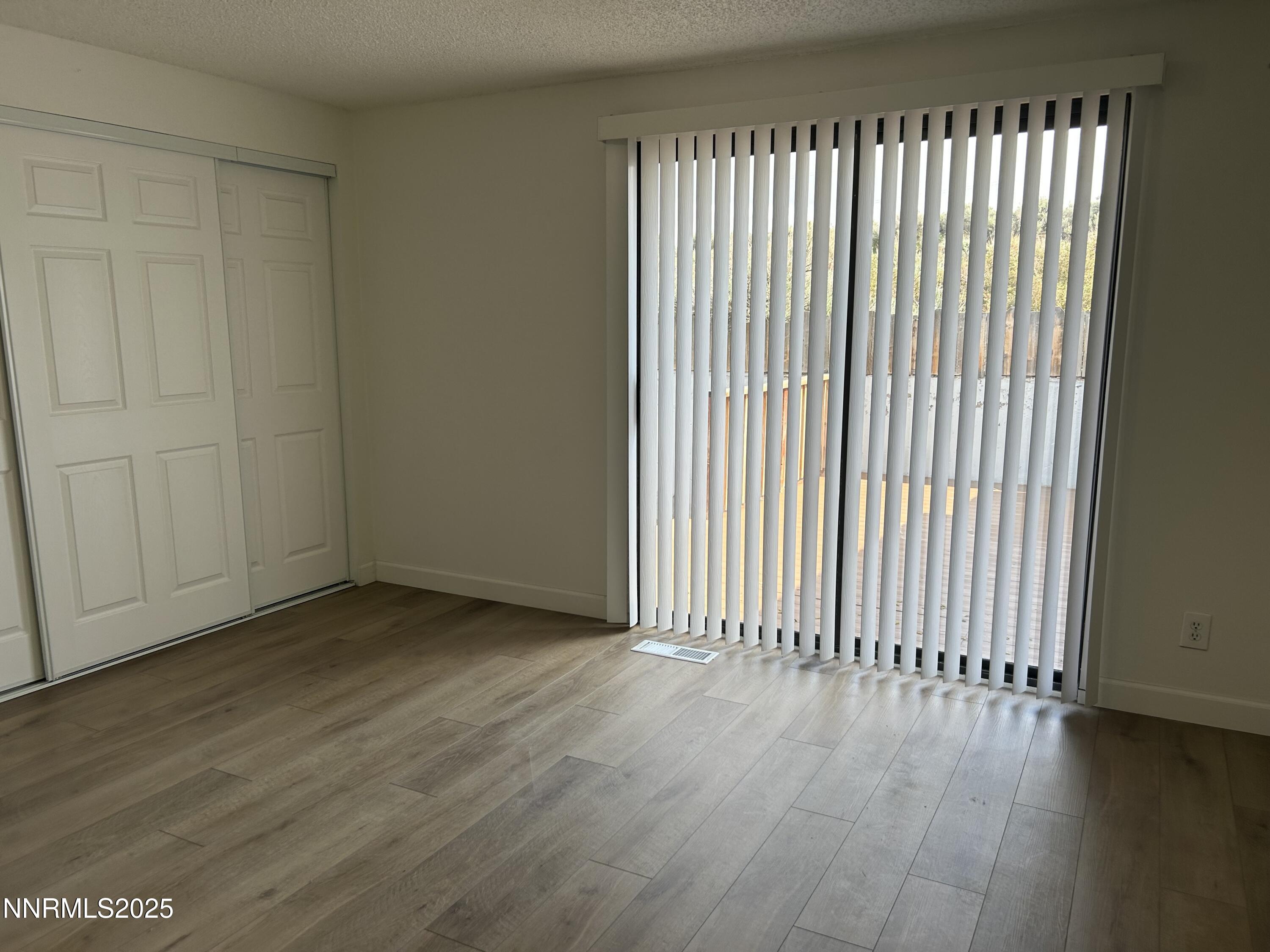 6780 Peppermint Drive Reno, NV 89506 - Photo 13 of 16 an empty room with wooden floor and windows
