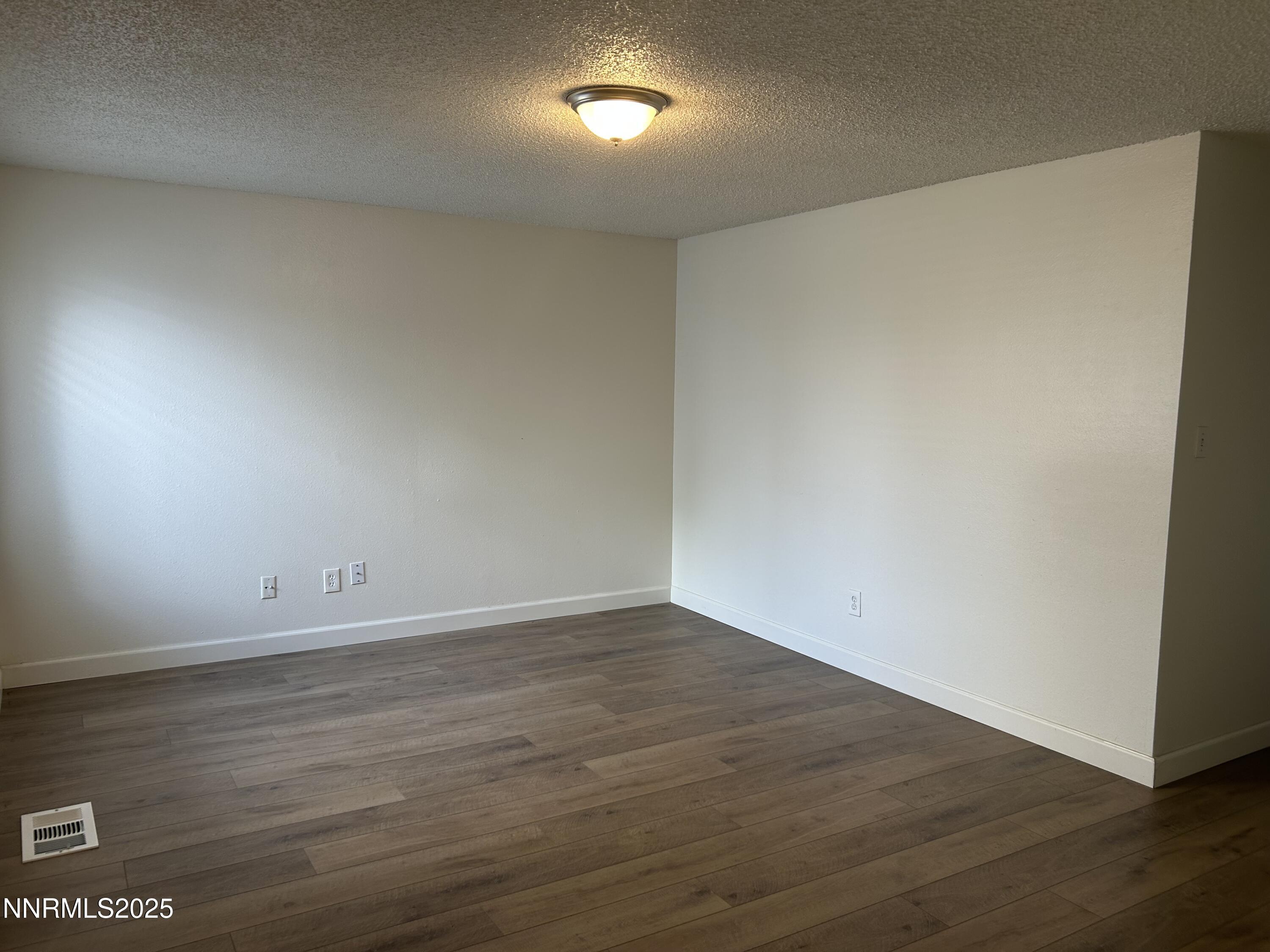 6780 Peppermint Drive Reno, NV 89506 - Photo 4 of 16 a view of an empty room with wooden floor and a window