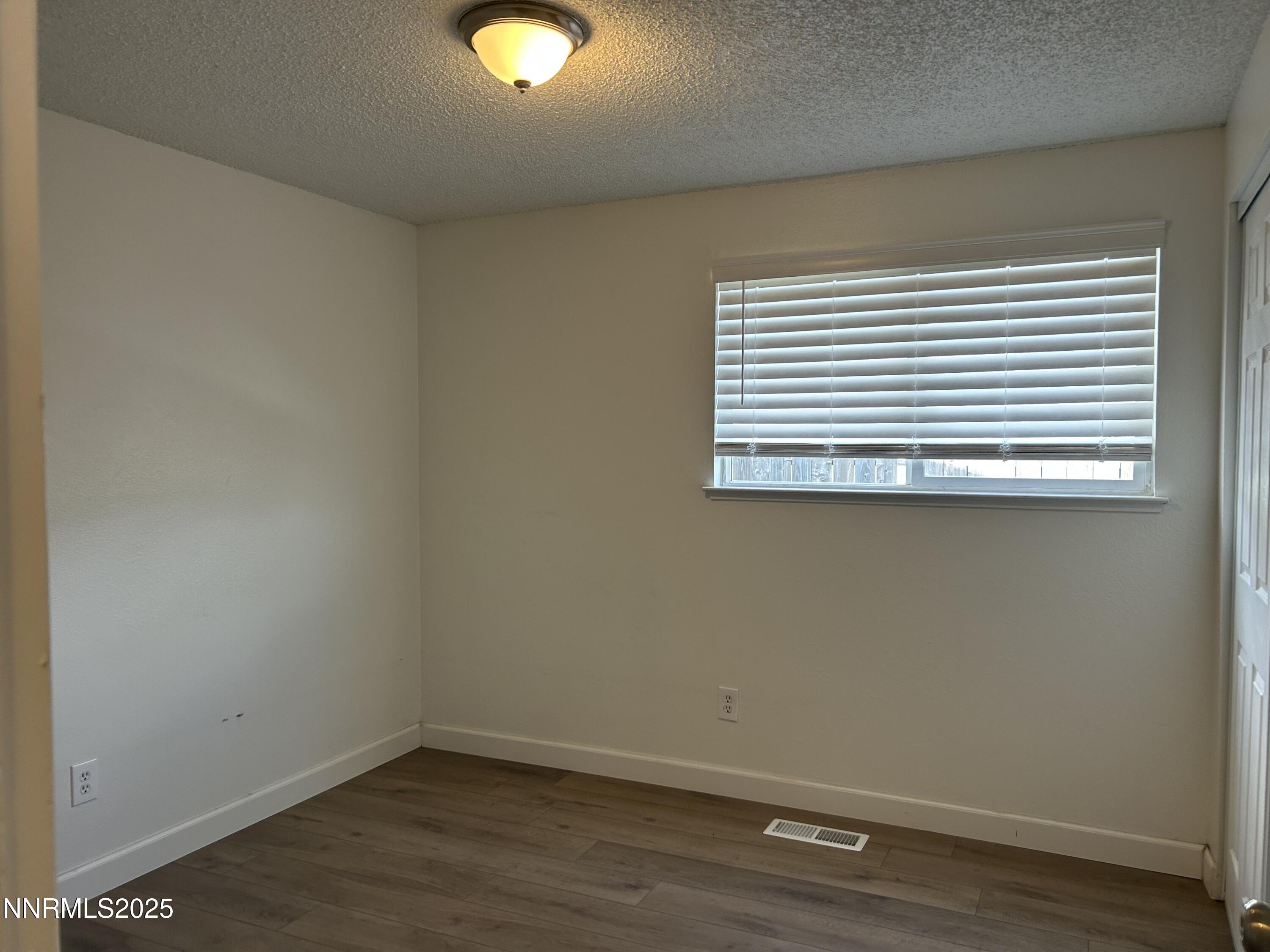 6780 Peppermint Drive Reno, NV 89506 - Photo 6 of 16 an empty room with wooden floor and windows