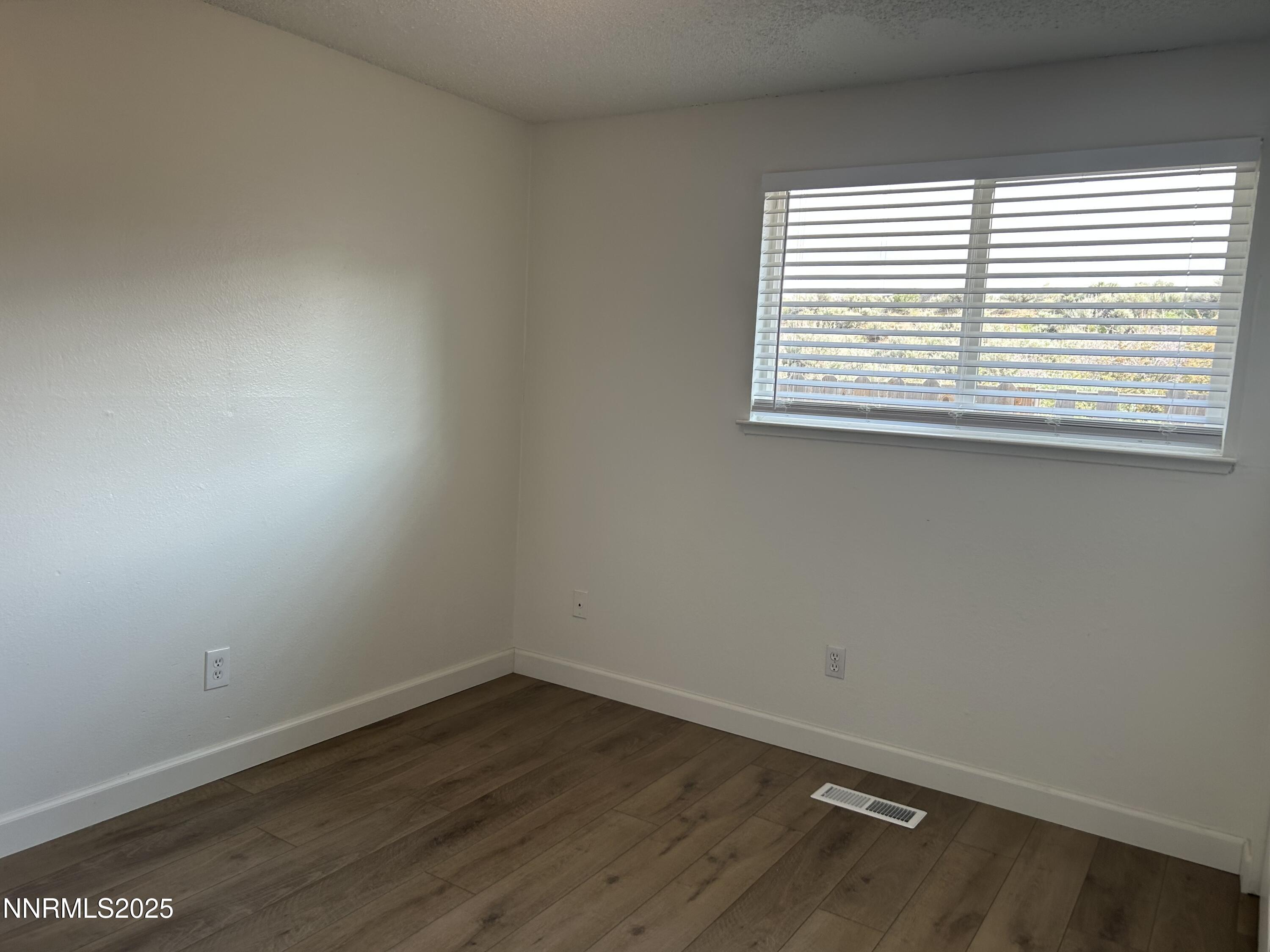 6780 Peppermint Drive Reno, NV 89506 - Photo 8 of 16 an empty room with wooden floor and a window
