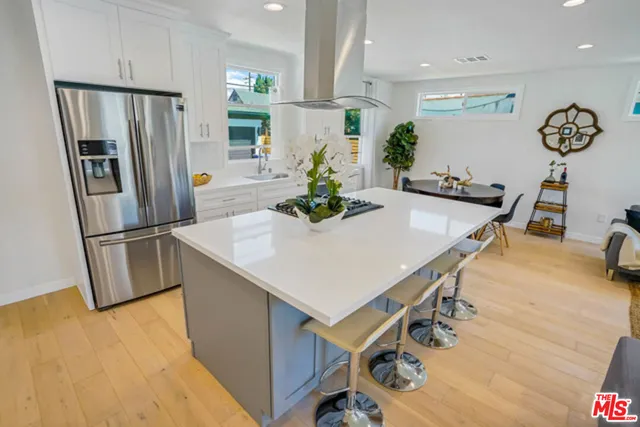 a kitchen with stainless steel appliances refrigerator dining table and chairs