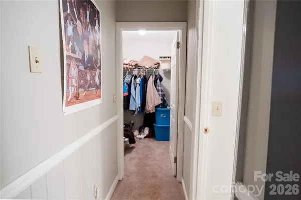 a bed sitting in a bedroom next to a lamp with a chandelier