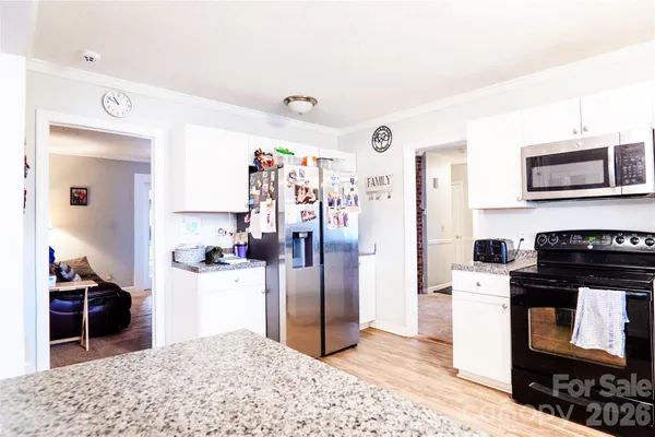 a kitchen with stainless steel appliances kitchen island granite countertop a refrigerator and a stove