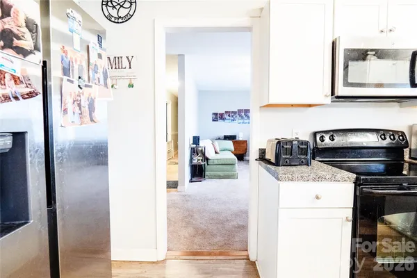 a room with lot of white furniture and a window