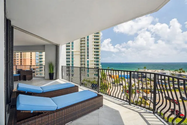 a bed sitting in a balcony with a large window