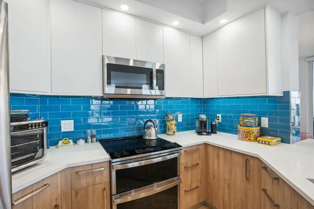 a kitchen with stainless steel appliances a stove a microwave a sink and cabinets