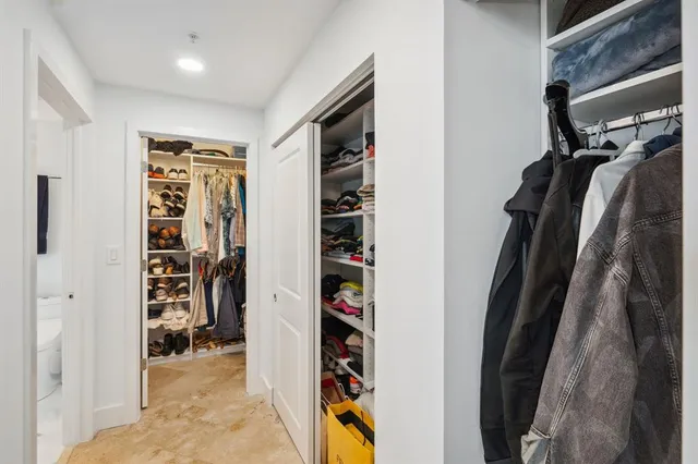 a view of walk in closet with clothes and shoes