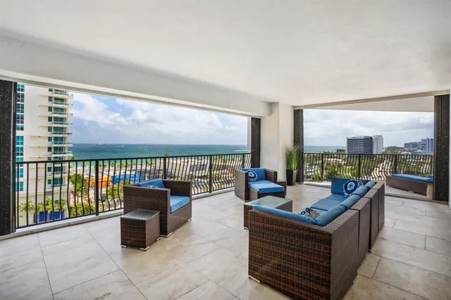 a living room with furniture and floor to ceiling windows
