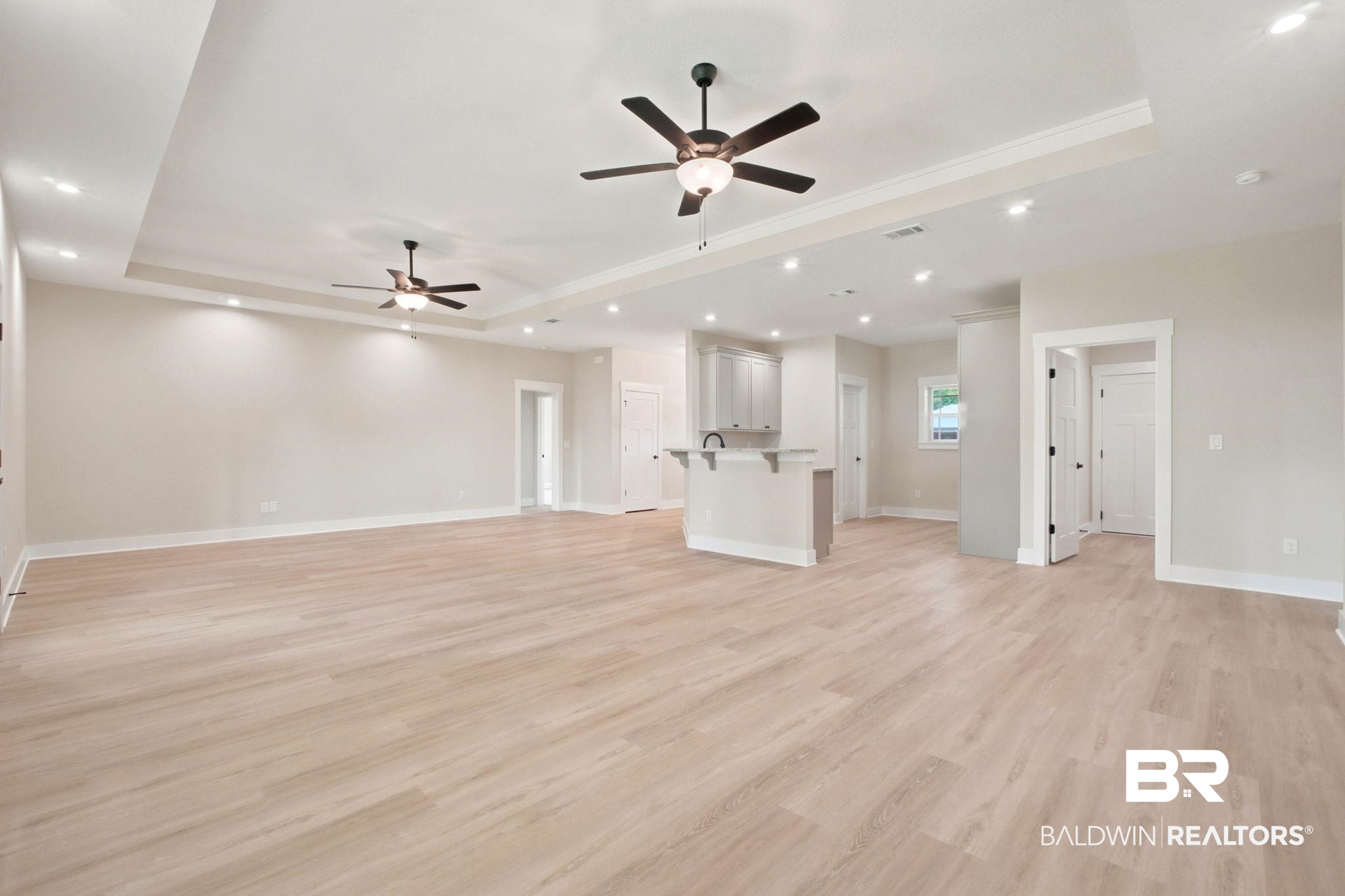 32656 Arbor Ridge Circle Lillian, AL 36549 - Photo 5 of 56 Spacious open-concept living area featuring light wood-finish flooring, tray ceilings with crown molding, and recessed lighting