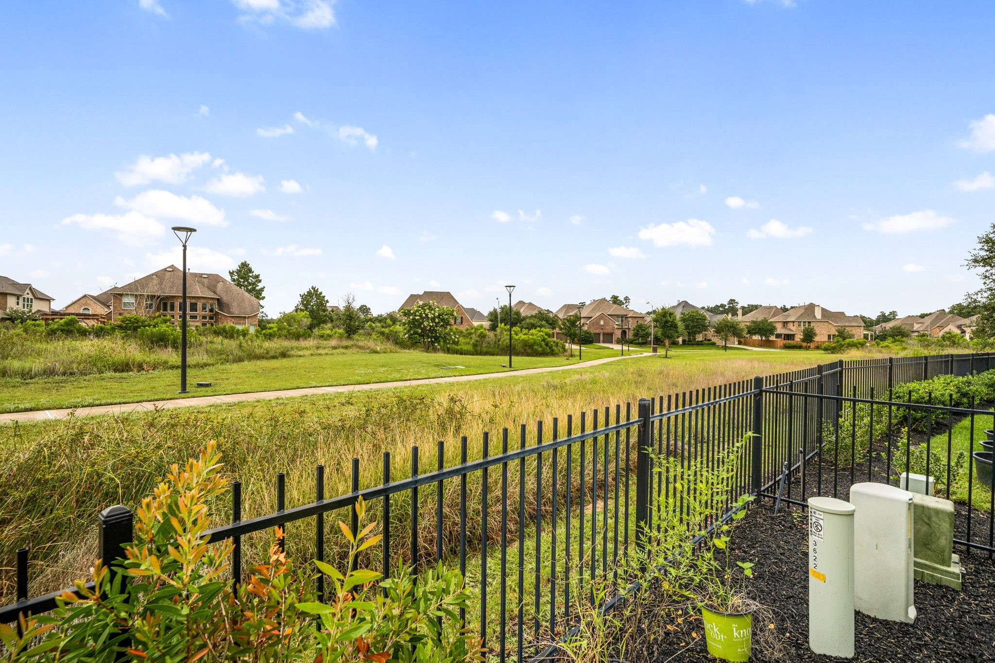 3622 Sage Hollow Drive Spring, TX 77386 - Photo 36 of 46 A view along the back wrought-iron fence line highlights the neighborhood's open-space layout, offering premium views of the surrounding community walking paths and natural landscape.