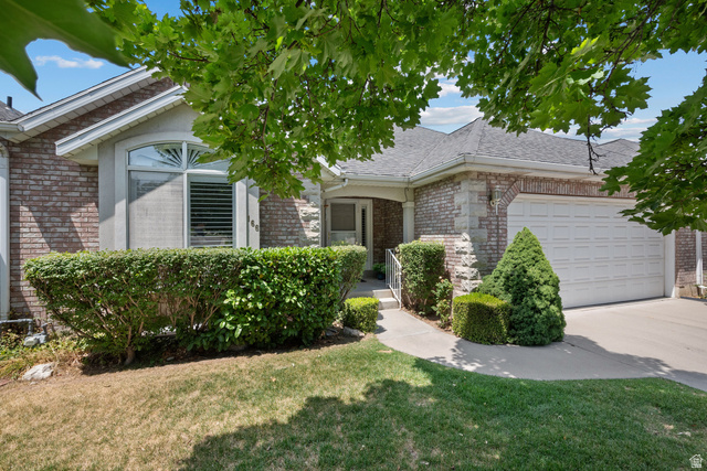166 South Ridgeview Drive Orem, UT 84058 - Photo 2 of 38 Brick and stone facade with arched window, attached garage, and manicured shrubbery