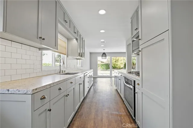 a kitchen with granite countertop a sink and wooden cabinets