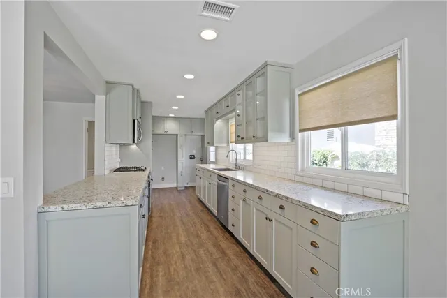a large kitchen with stainless steel appliances granite countertop a lot of counter space and a sink
