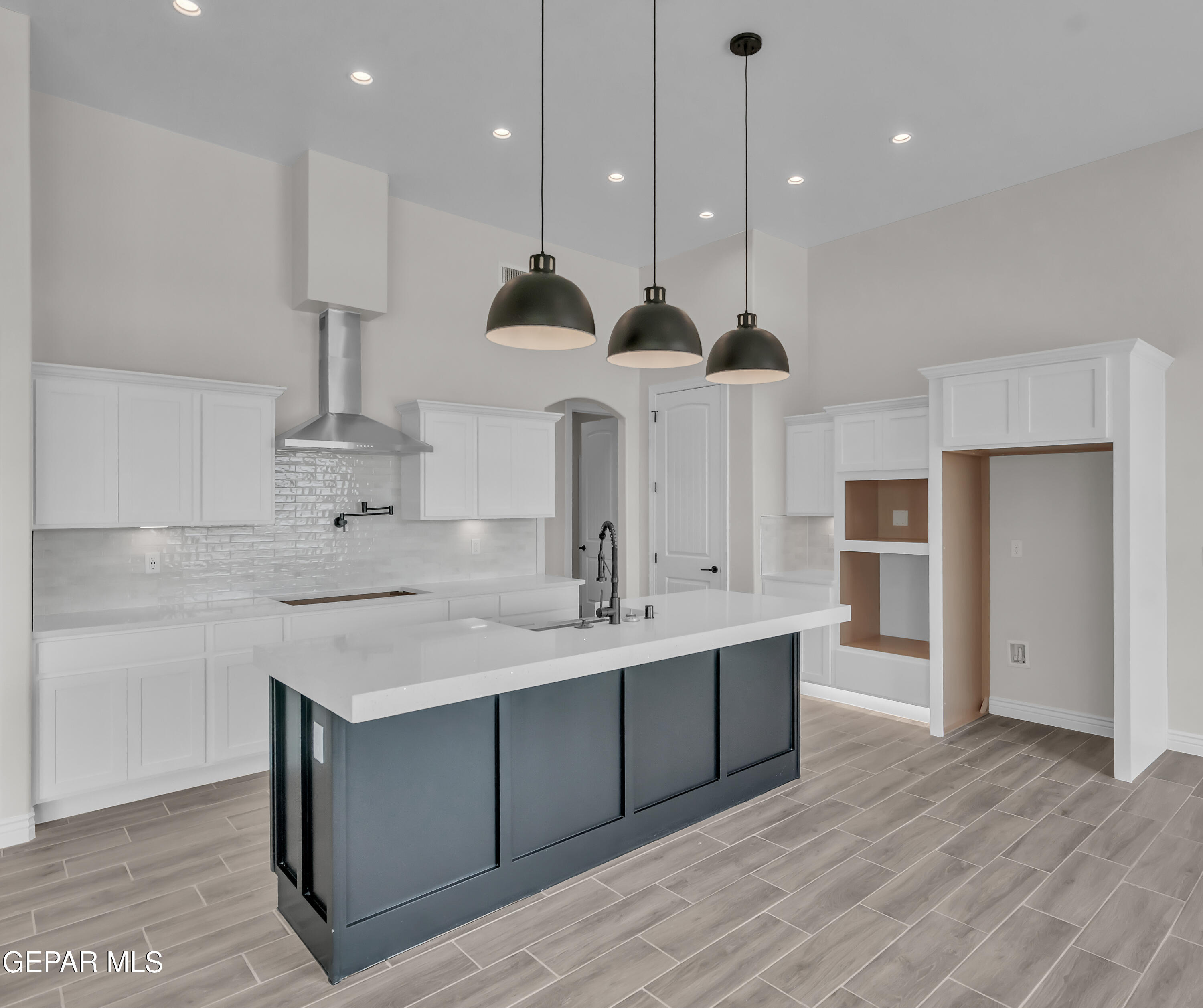 1849 War Path El Paso, TX 79911 - Photo 11 of 18 a large kitchen with stainless steel appliances kitchen island a large counter top a sink cabinets and a wooden floor