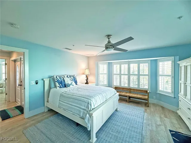 a bedroom with a bed and large windows