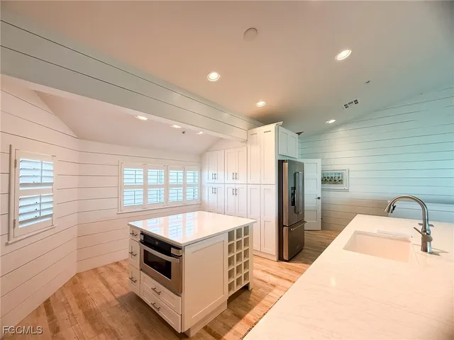 a kitchen with stainless steel appliances a sink and a refrigerator