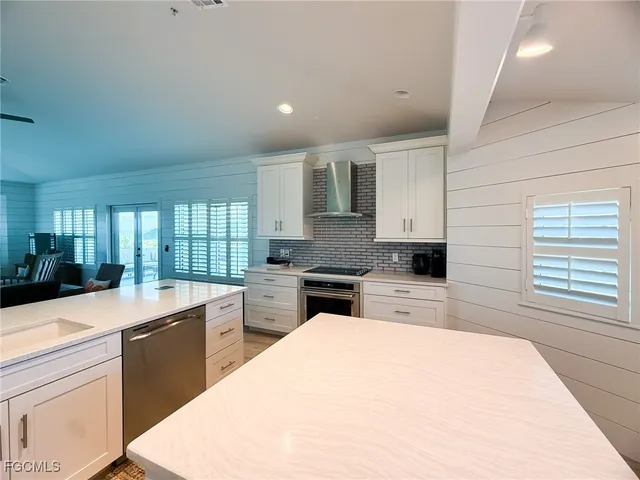 a large kitchen with kitchen island a sink stainless steel appliances and cabinets