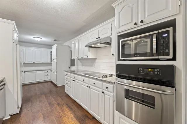 a kitchen with sink stove and cabinets