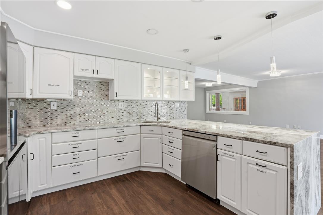 6271 Batman Road Zionsville, PA 18092 - Photo 19 of 100 Bright, open-concept kitchen showcasing a waterfall-edge island, integrated sink, and modern pendant lighting.