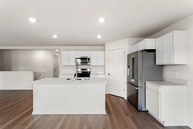 a kitchen with stainless steel appliances a refrigerator sink and cabinets