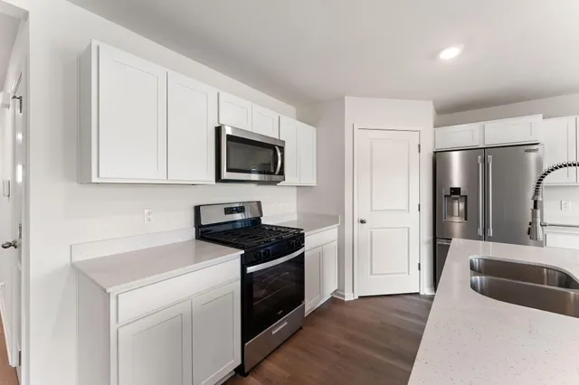 a kitchen with stainless steel appliances a stove microwave and refrigerator