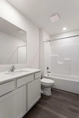 a bathroom with a double vanity sink toilet mirror and bathtub