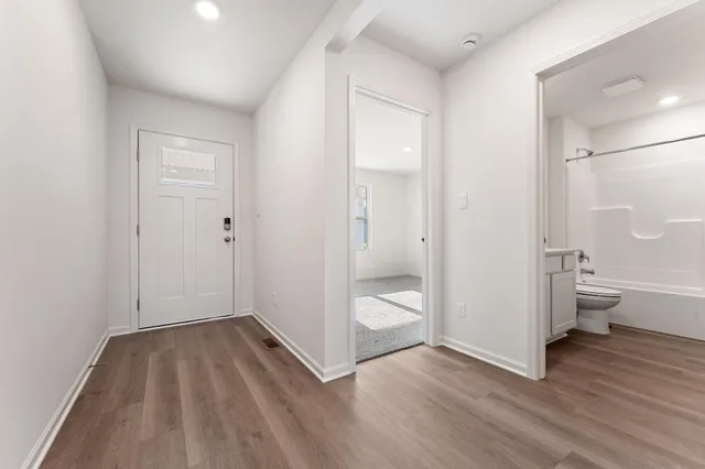 a view of a room with wooden floor and bathroom space
