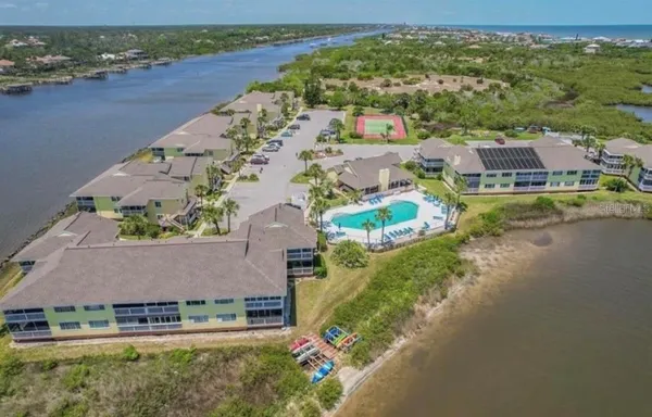 an aerial view of residential houses with outdoor space and river