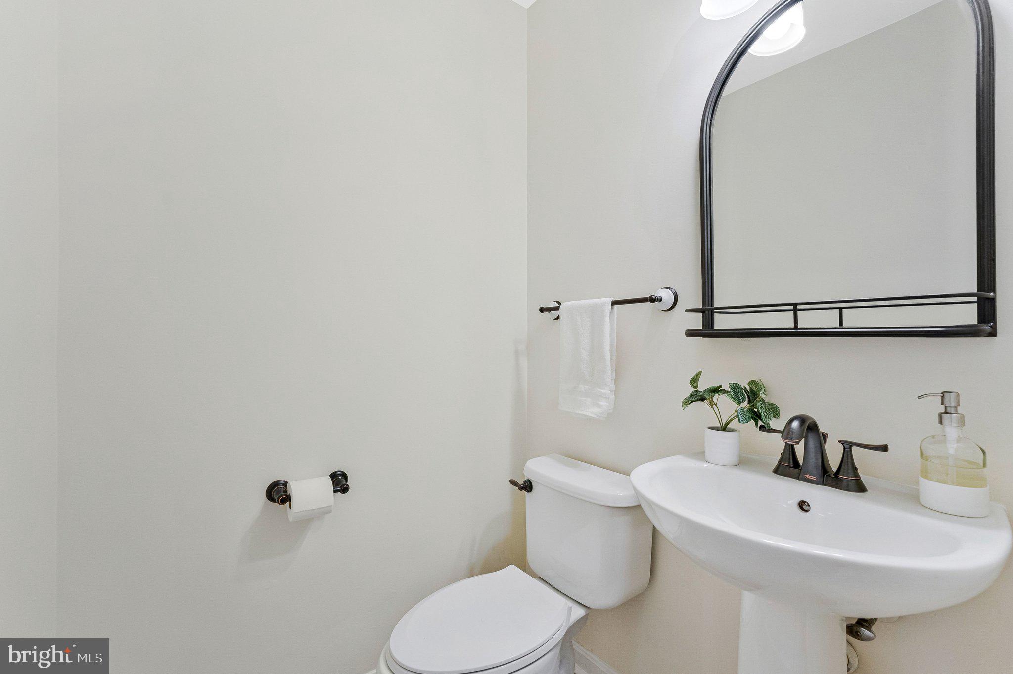 21789 Baldwin Square, Unit 21789 Sterling, VA 20164 - Photo 14 of 33 a bathroom with a sink a toilet and mirror