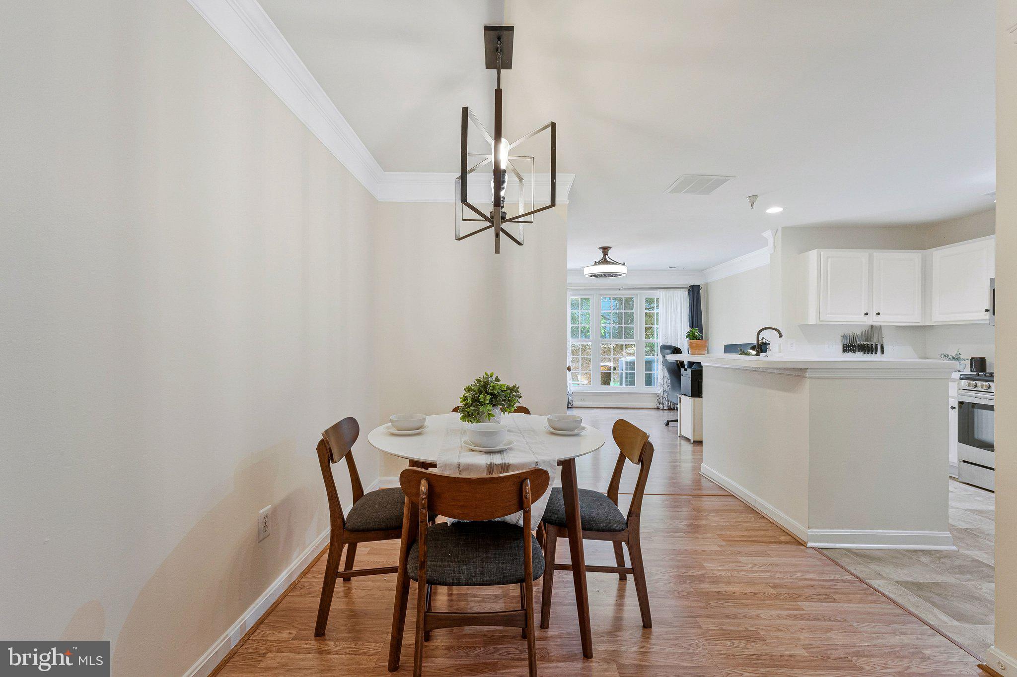 21789 Baldwin Square, Unit 21789 Sterling, VA 20164 - Photo 5 of 33 a view of a dining room with furniture and wooden floor