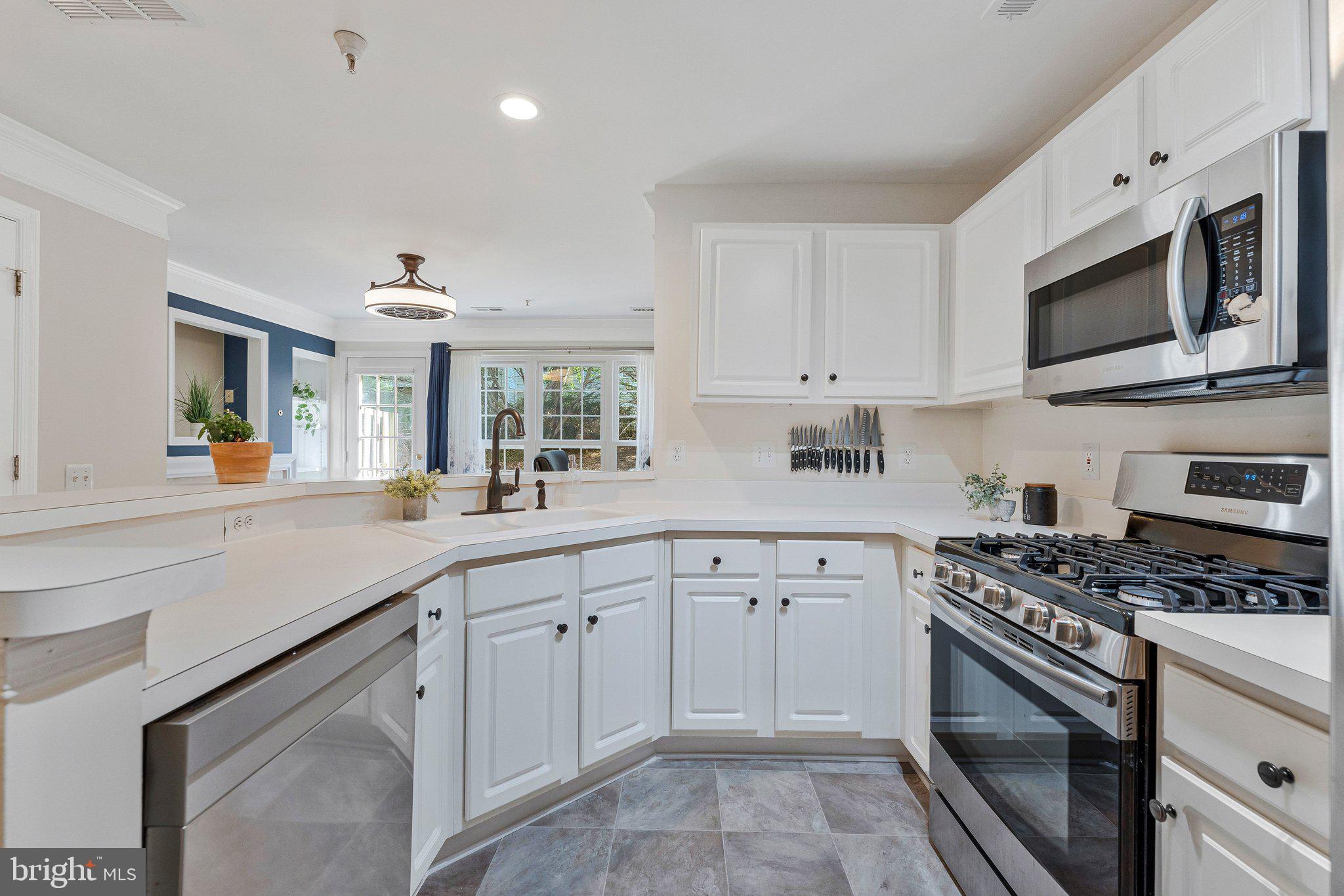 21789 Baldwin Square, Unit 21789 Sterling, VA 20164 - Photo 7 of 33 a kitchen with cabinets stainless steel appliances and a sink