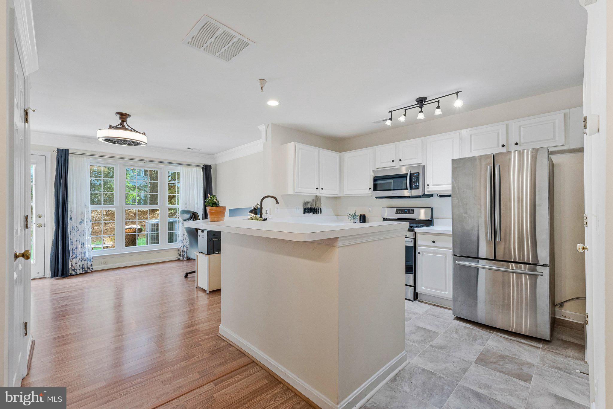 21789 Baldwin Square, Unit 21789 Sterling, VA 20164 - Photo 8 of 33 a kitchen with refrigerator cabinets and wooden floor