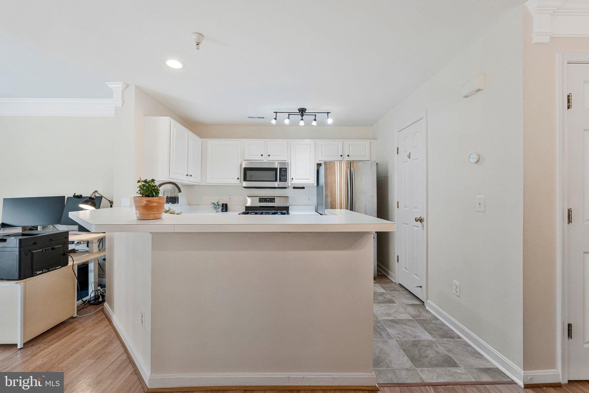 21789 Baldwin Square, Unit 21789 Sterling, VA 20164 - Photo 9 of 33 a kitchen with stainless steel appliances a refrigerator stove and microwave