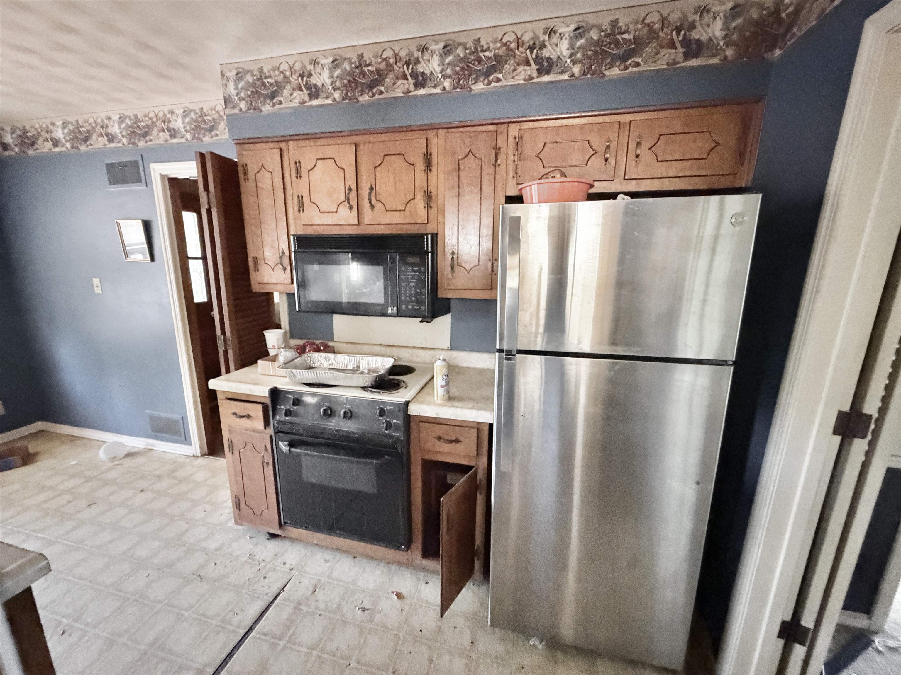 5536 Cottonwood Road Memphis, TN 38115 - Photo 4 of 28 Kitchen featuring wood cabinetry, a built-in microwave, an electric range, and a stainless steel refrigerator