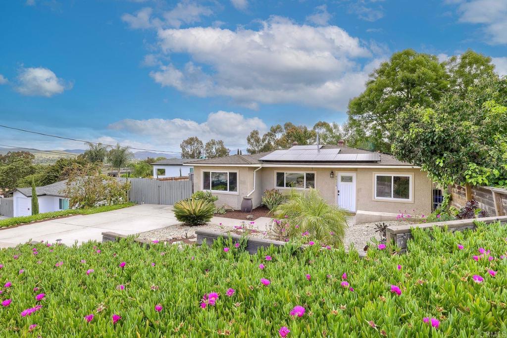 a view of a house with a big yard and potted plants