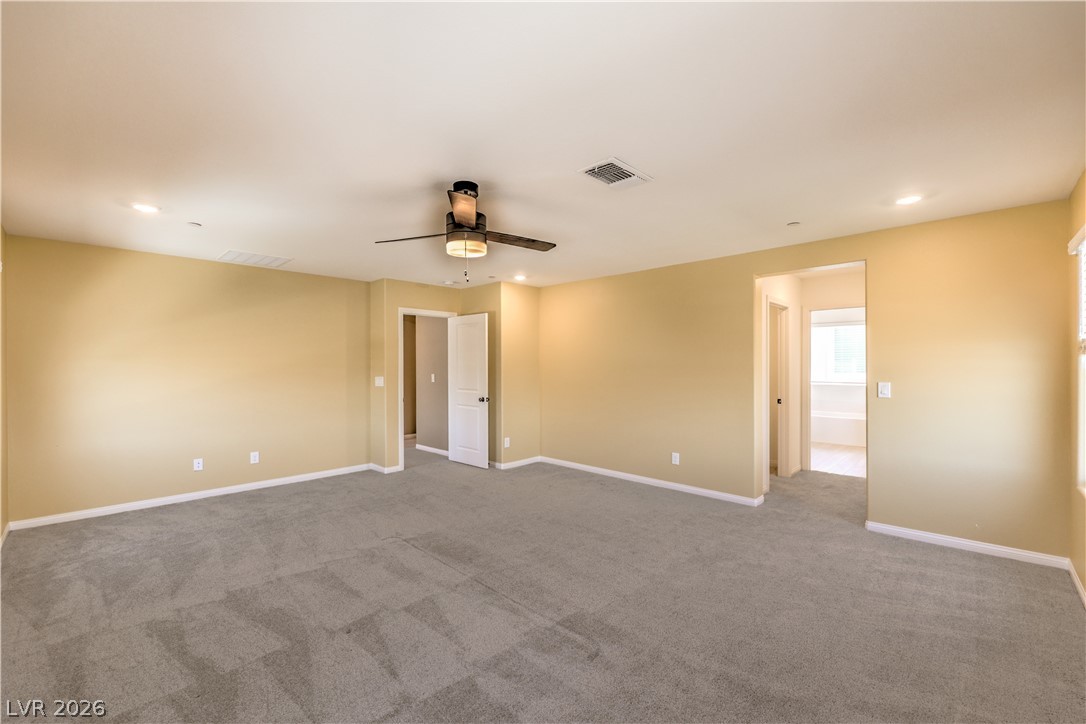3782 Alla Rocca Avenue Henderson, NV 89044 - Photo 23 of 55 This spacious primary bedroom features soft carpeting and convenient access to a private bathroom.