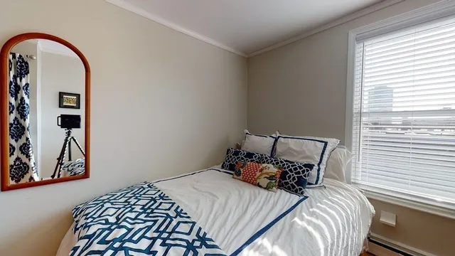 a bed sitting in a bedroom next to a window