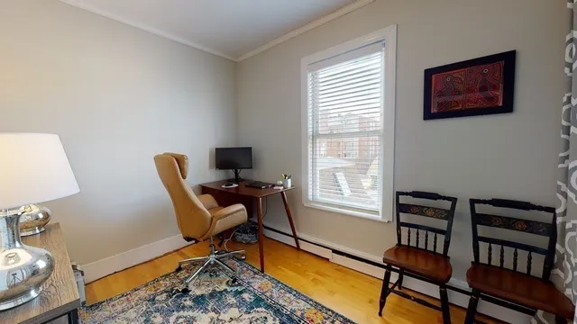 a view of a workspace with furniture and a window