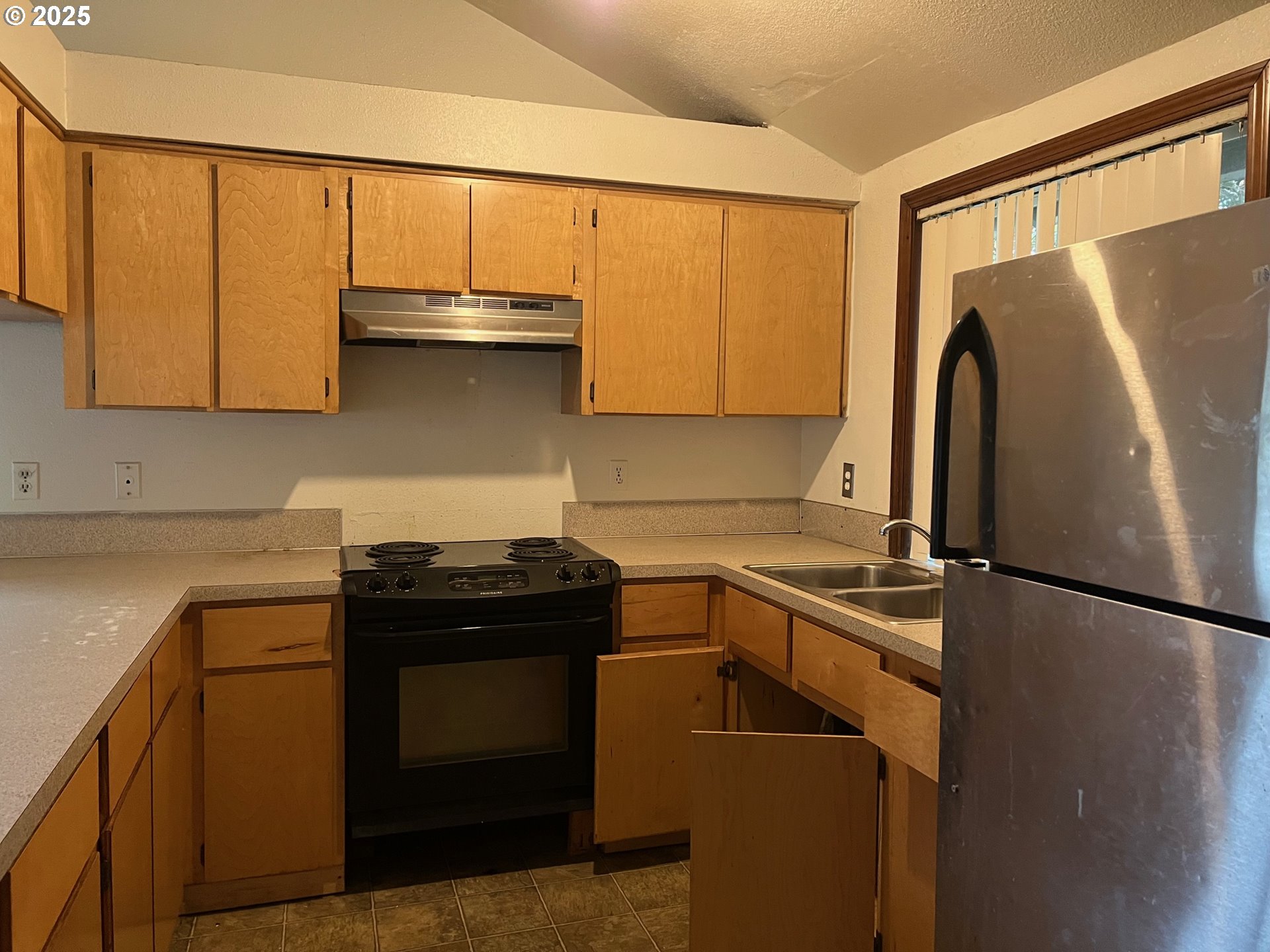18830 Southwest Butternut Street Beaverton, OR 97078 - Photo 4 of 13 a kitchen with a sink a refrigerator and a stove