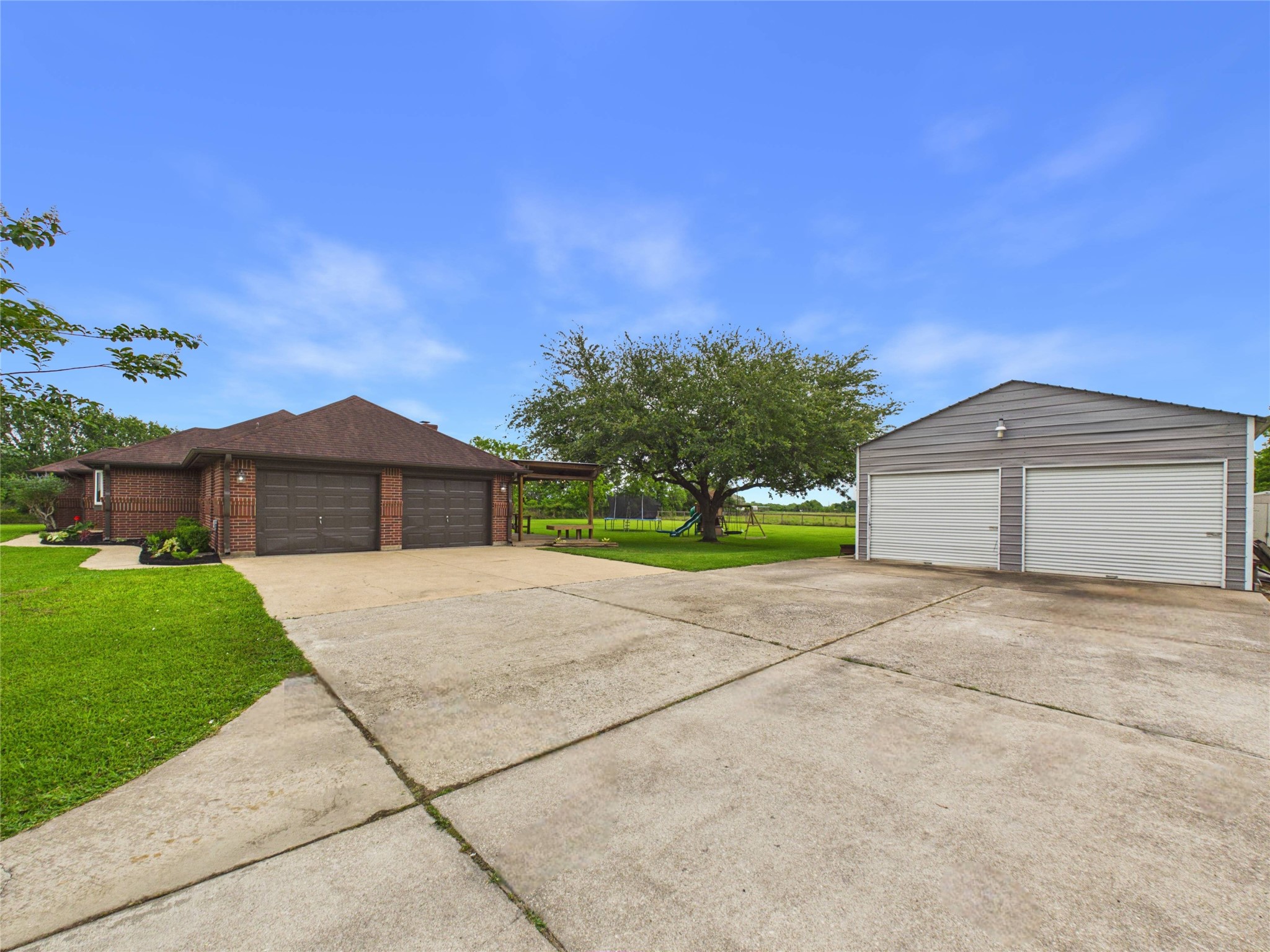 4610 Mustang Road Alvin, TX 77511 - Photo 6 of 50 Side entry attached garage and updated covered back patio that with a swing offering a comfy spot for morning coffee. Enjoy the unobstructed view of children playing or horses grazing (OR BOTH)