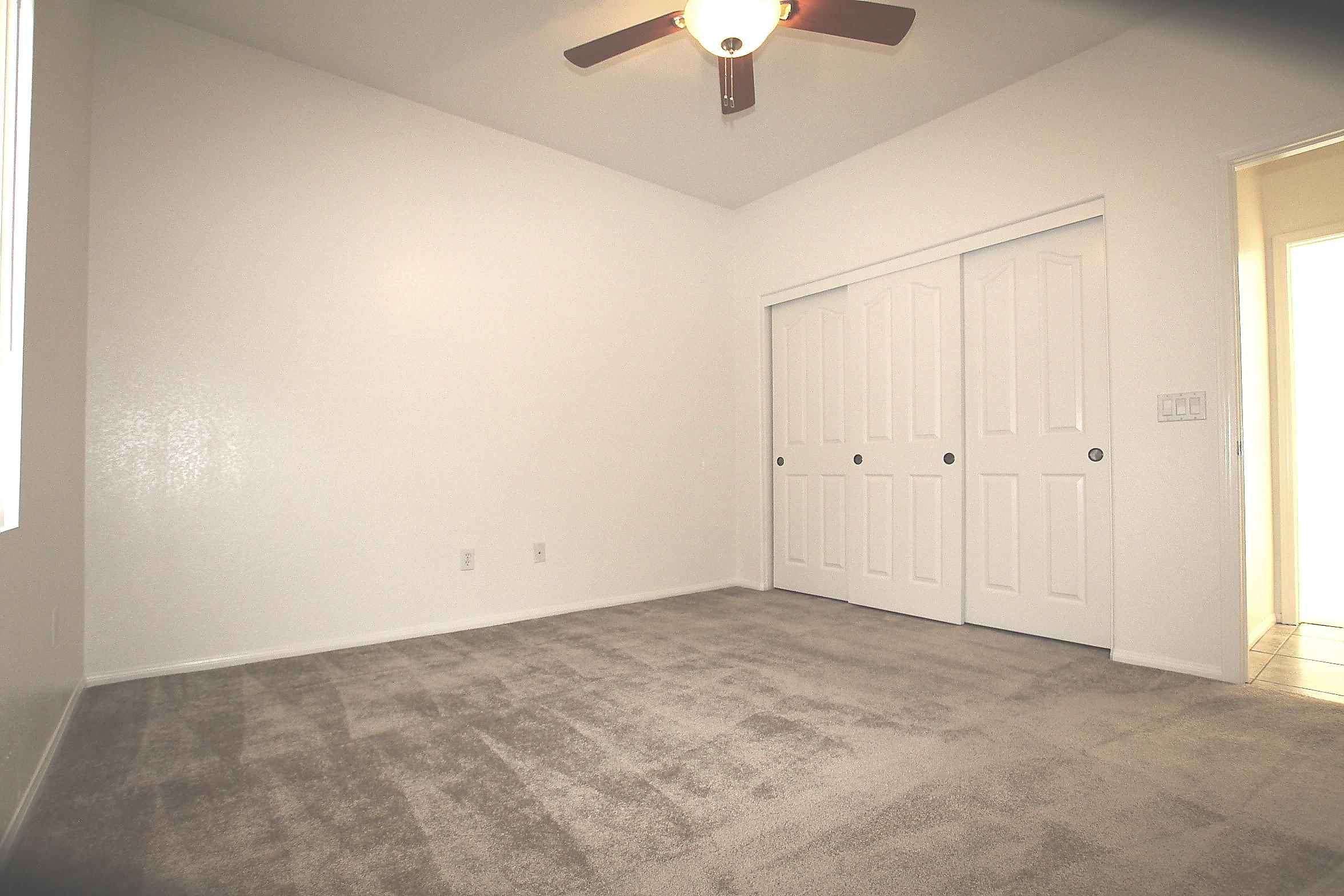 2104 Avenue J7 W Lancaster Ca West Lancaster, CA 93536 - Photo 11 of 18 an empty room with a ceiling fan and a window