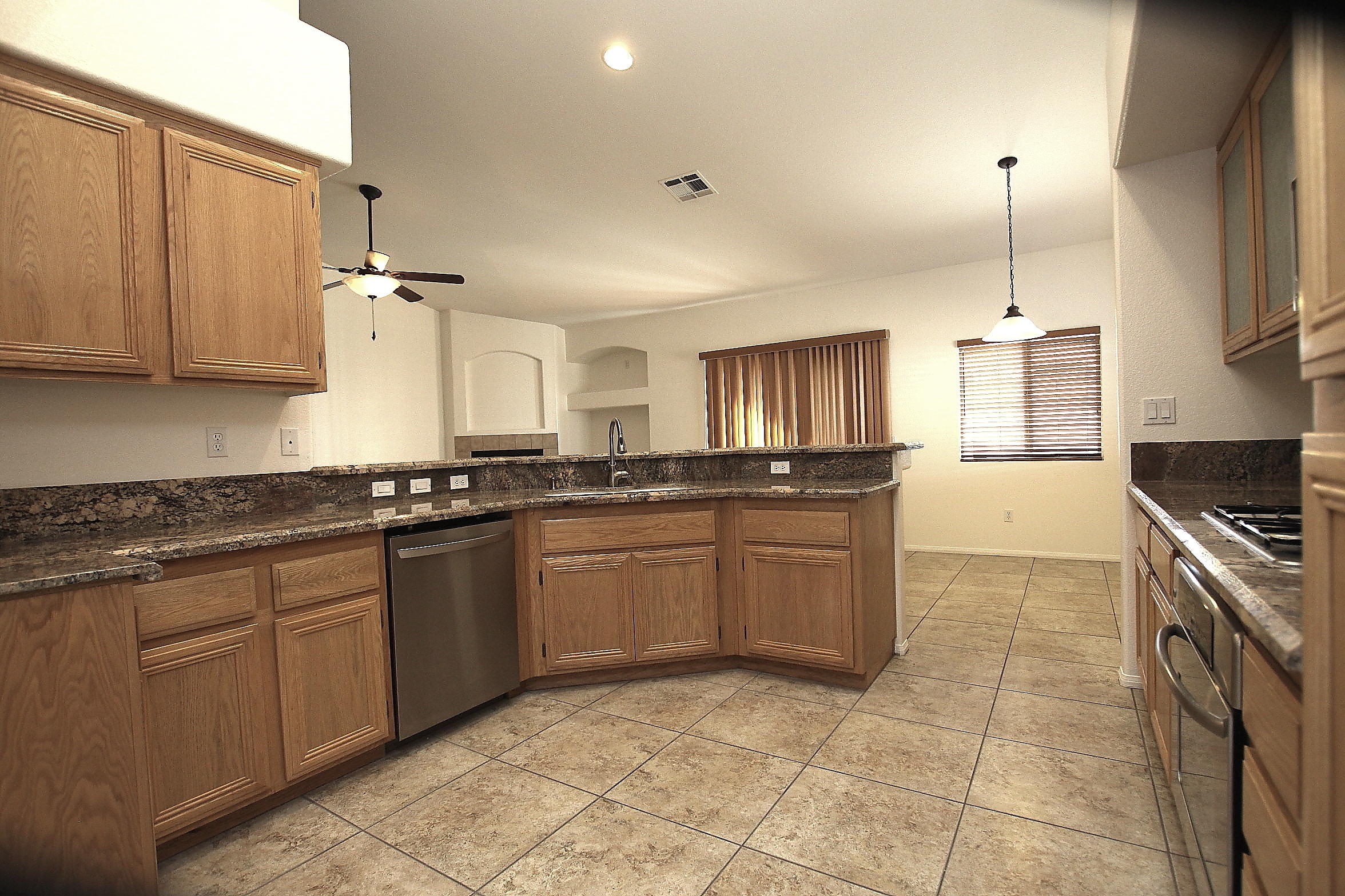 2104 Avenue J7 W Lancaster Ca West Lancaster, CA 93536 - Photo 4 of 18 a large kitchen with granite countertop a stove a sink dishwasher and a refrigerator