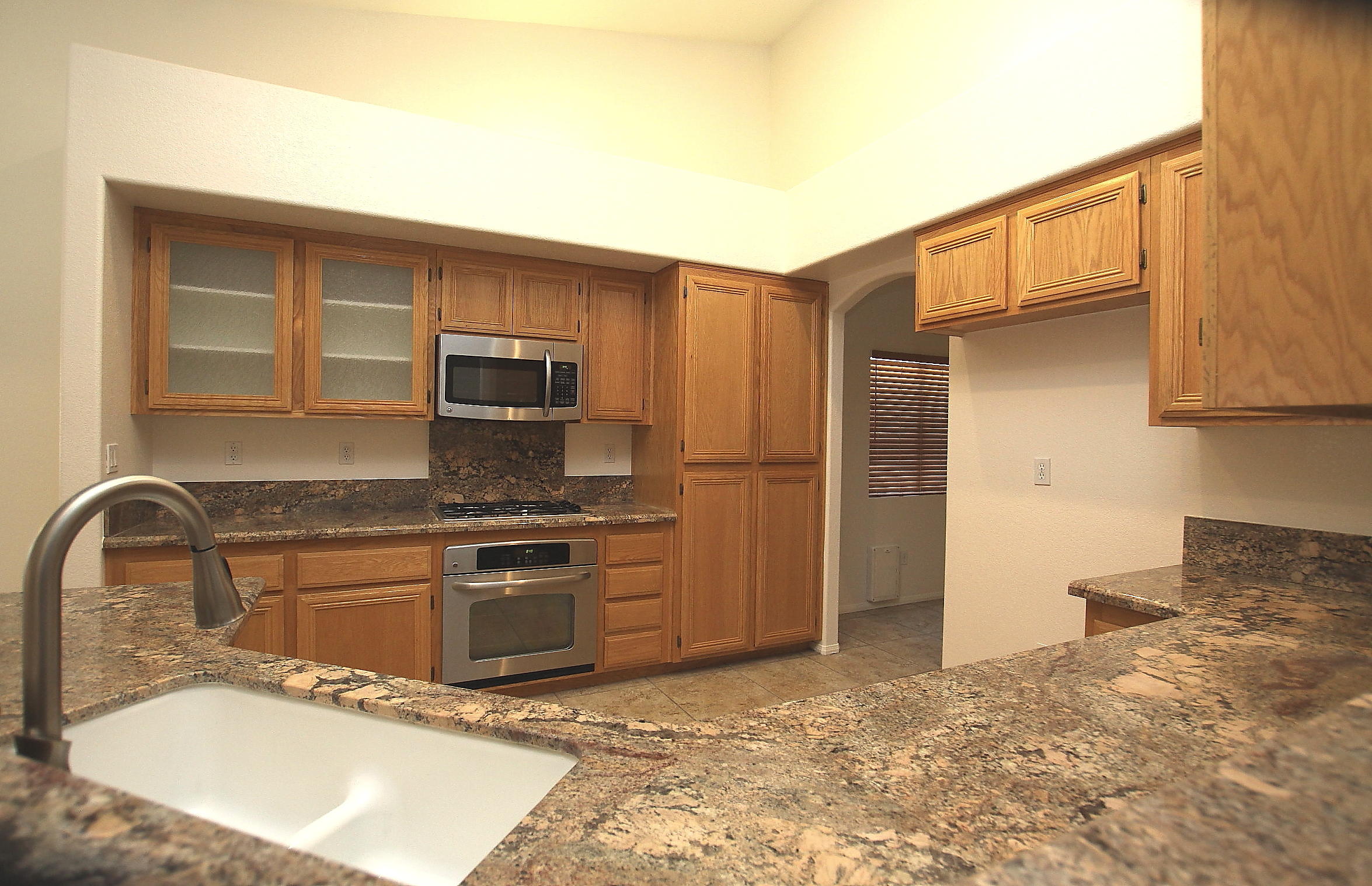 2104 Avenue J7 W Lancaster Ca West Lancaster, CA 93536 - Photo 5 of 18 a kitchen with stainless steel appliances granite countertop a stove a sink and a microwave