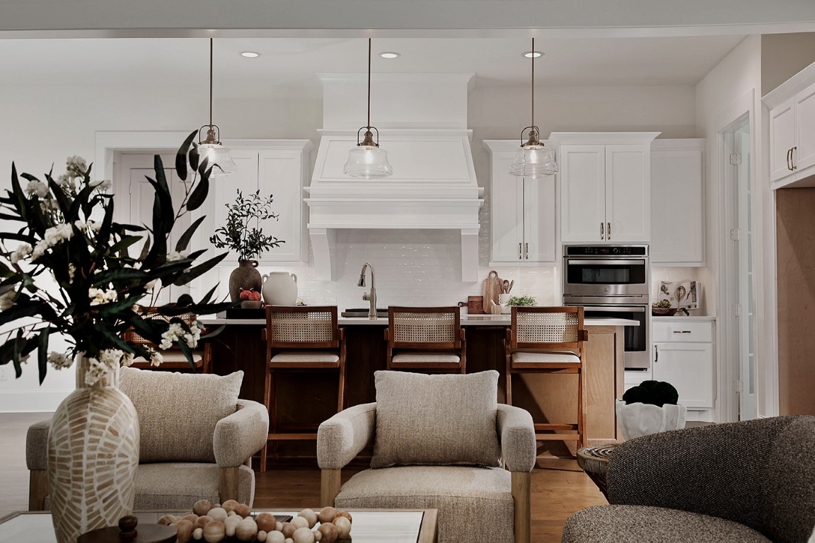 11709 Grand N Road Willis, TX 77378 - Photo 10 of 37 The modern, open-concept kitchen features a crisp, white color palette with wooden accents and elegant pendant lighting.