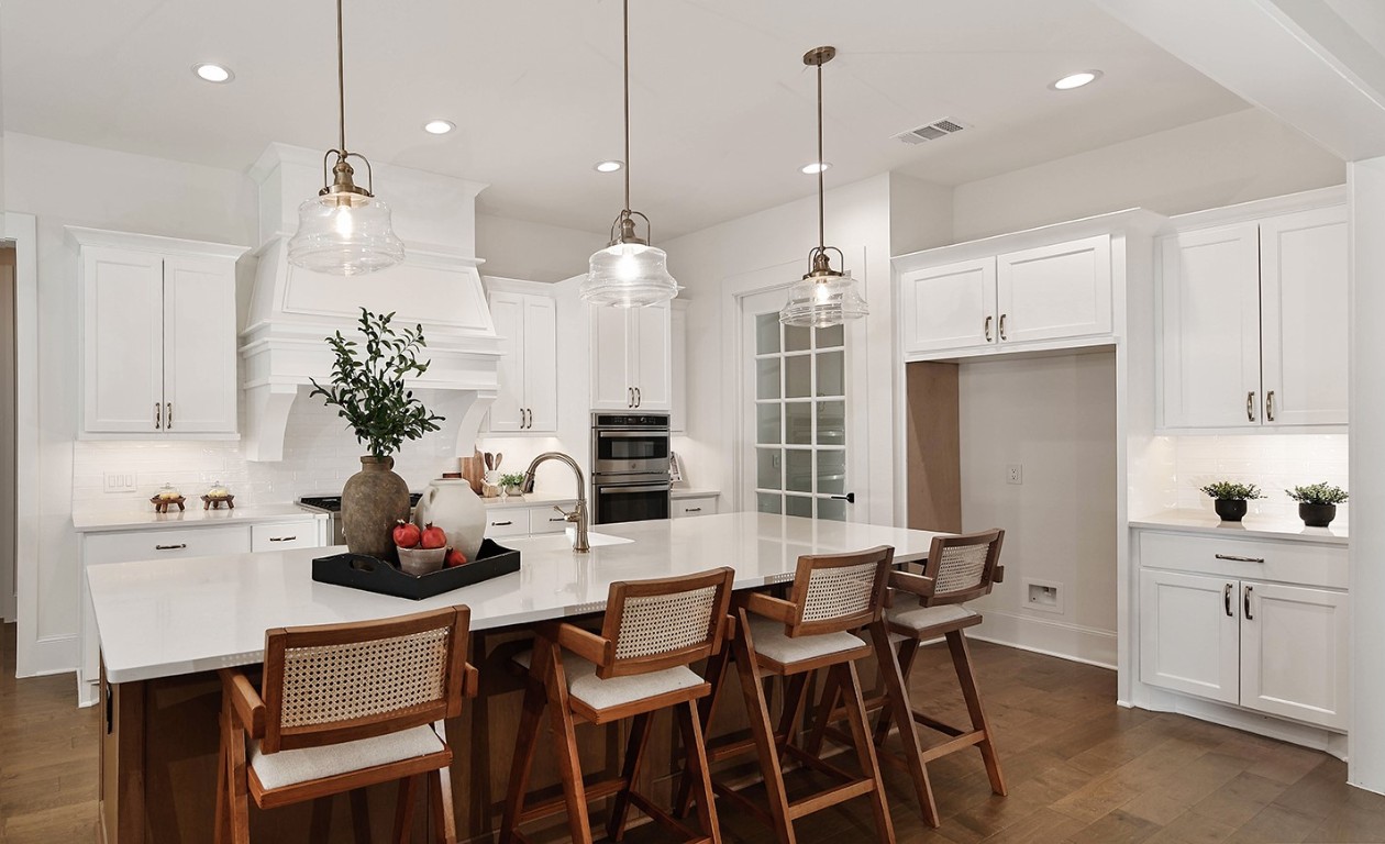11709 Grand N Road Willis, TX 77378 - Photo 11 of 37 The large central island is finished in gorgeous stained wood with quartz counters, sleek stainless steel appliances and french oak wood flooring add warmth and ambiance in this beautiful kitchen.